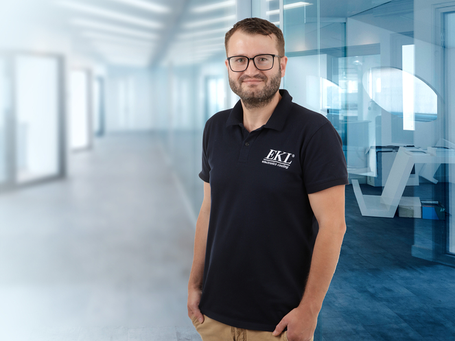 Auf dem Bild ist eine Person in einem dunkelblauen Poloshirt mit dem Schriftzug